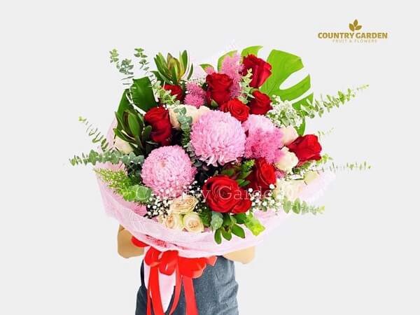 Bó hoa mẫu đơn hồng kết hợp với hoa hồng đỏ, hoa hồng vàng nhạt và hoa bi trắng